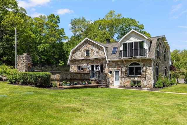 135 Eagleville Rd, Tiverton, RI 02878 - view of front of house featuring a gambrel roof, stone siding, a front lawn, a shingled roof, and a balcony