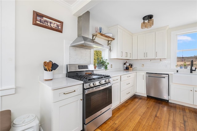 4588 Main Rd, Tiverton, RI 02878 - kitchen with light countertops, appliances with stainless steel finishes, a sink, wall chimney range hood, and backsplash