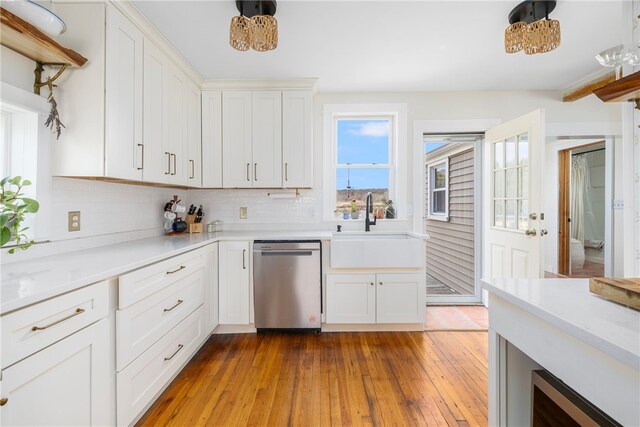 4588 Main Rd, Tiverton, RI 02878 - kitchen with white cabinets, tasteful backsplash, a sink, hardwood / wood-style floors, and stainless steel dishwasher