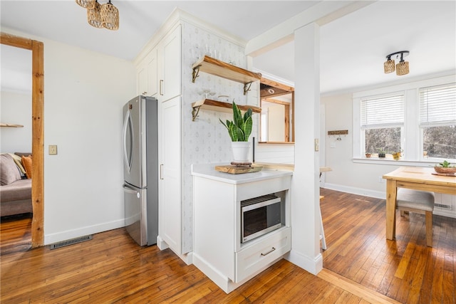 4588 Main Rd, Tiverton, RI 02878 - kitchen featuring visible vents, baseboards, stainless steel appliances, white cabinetry, and hardwood / wood-style floors