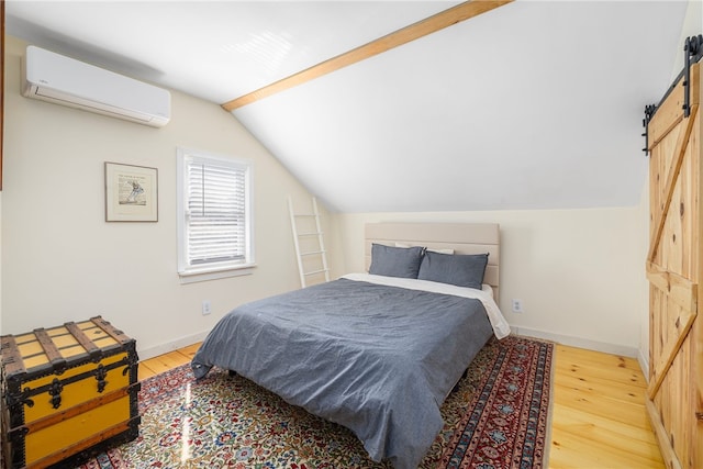 4588 Main Rd, Tiverton, RI 02878 - bedroom with hardwood / wood-style floors, a wall unit AC, a barn door, and lofted ceiling