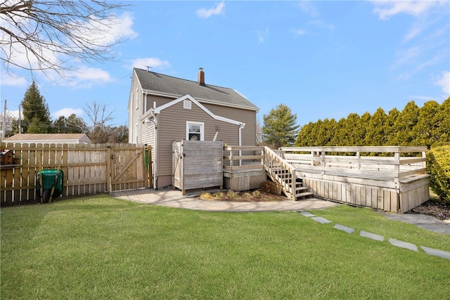 4588 Main Rd, Tiverton, RI 02878 - back of house with a gate, a chimney, a wooden deck, fence, and a lawn