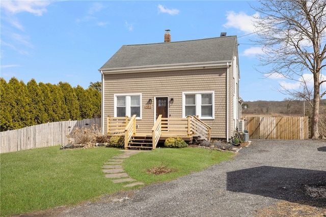 4588 Main Rd, Tiverton, RI 02878 - view of front of house featuring a chimney, fence, roof with shingles, and a front yard