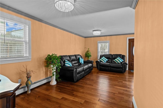 living area with wood-type flooring, an inviting chandelier, crown molding, and a baseboard heating unit