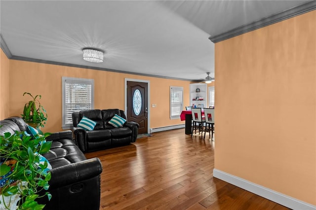 living area with ornamental molding, dark wood-type flooring, baseboards, a ceiling fan, and baseboard heating