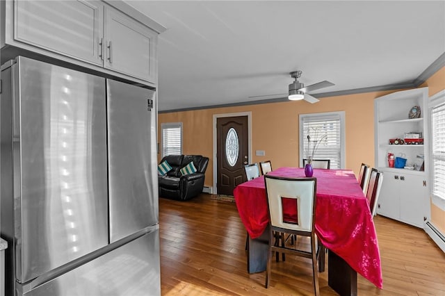dining room with wood-type flooring, a ceiling fan, plenty of natural light, and ornamental molding