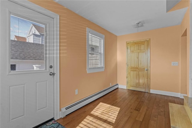 foyer featuring plenty of natural light, baseboards, a baseboard heating unit, and hardwood / wood-style flooring