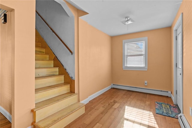 interior space featuring a baseboard radiator, baseboards, and wood-type flooring