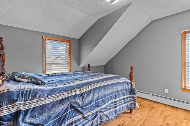 bedroom with a baseboard radiator, lofted ceiling, multiple windows, and wood finished floors