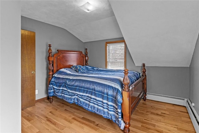 bedroom featuring wood finished floors, vaulted ceiling, baseboards, a baseboard radiator, and baseboard heating