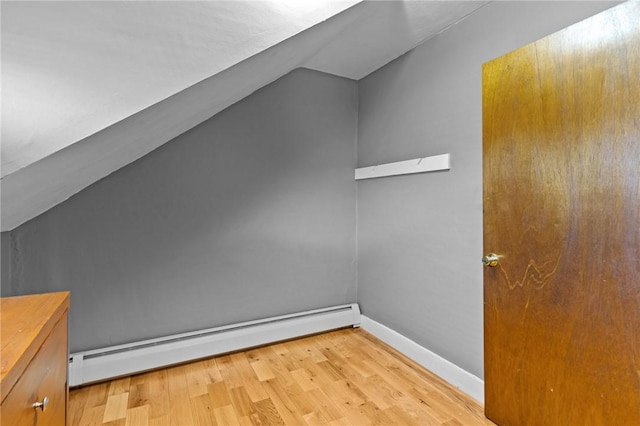bonus room featuring baseboards, vaulted ceiling, light wood-type flooring, and a baseboard radiator