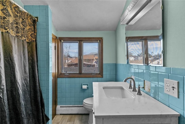 bathroom featuring tile walls, toilet, baseboard heating, curtained shower, and wood finished floors