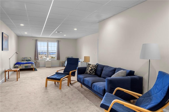carpeted living area featuring baseboards, a drop ceiling, and recessed lighting