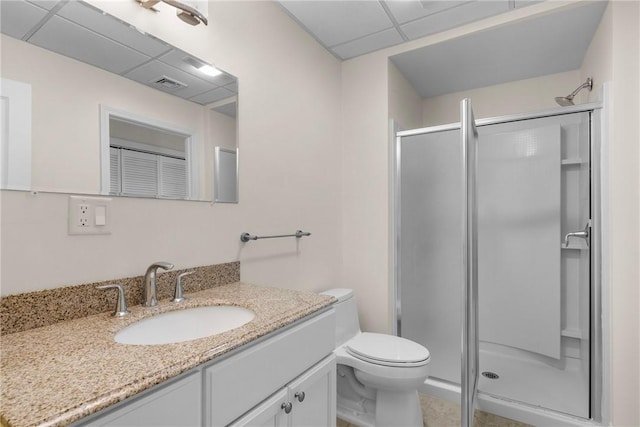 full bath featuring toilet, vanity, a shower stall, visible vents, and a drop ceiling