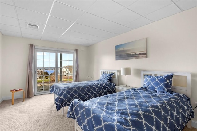 bedroom featuring access to outside, baseboards, visible vents, carpet, and a paneled ceiling