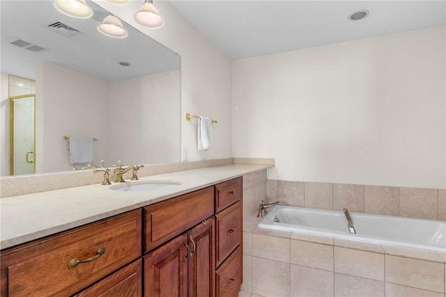 bathroom featuring vanity, visible vents, a garden tub, and a shower stall