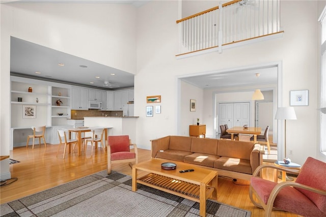 living area with light wood-type flooring and a high ceiling