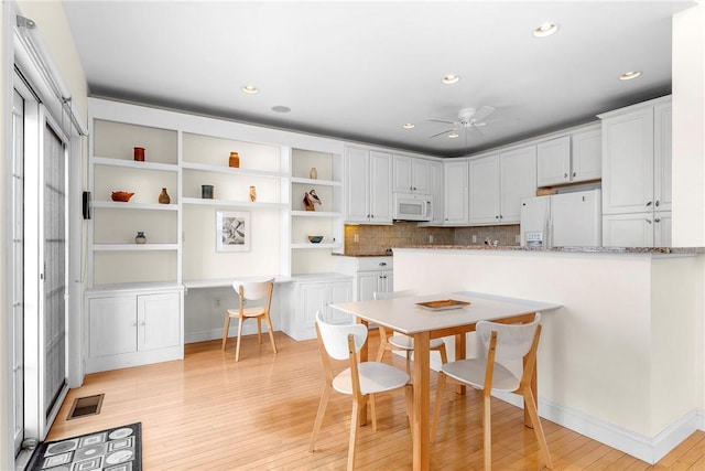 kitchen featuring visible vents, white appliances, a ceiling fan, white cabinetry, and light wood-type flooring