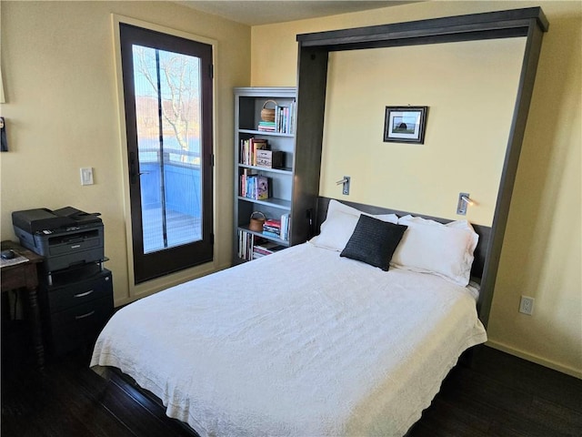 bedroom featuring access to outside, wood finished floors, and baseboards
