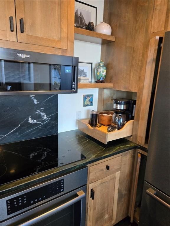 kitchen featuring appliances with stainless steel finishes, open shelves, and dark countertops