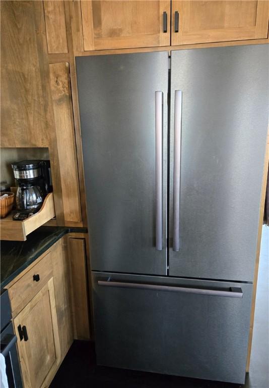 kitchen view of freestanding refrigerator and dark countertops