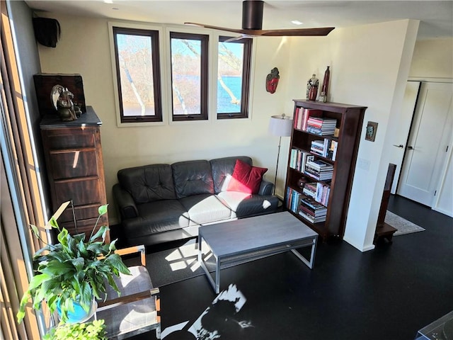 living room featuring a ceiling fan and baseboards