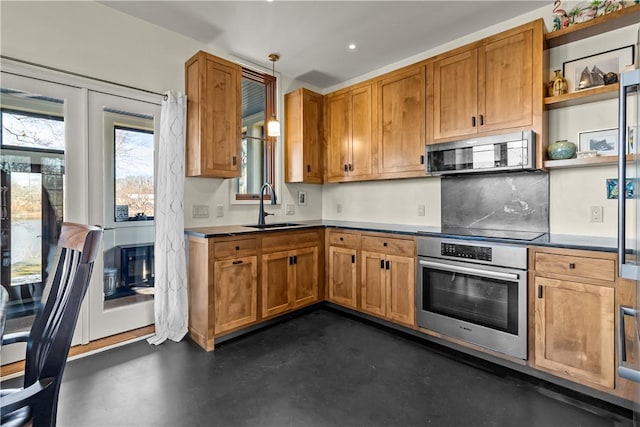 kitchen featuring stainless steel appliances, a sink, finished concrete floors, open shelves, and hanging light fixtures