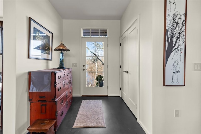 doorway to outside featuring finished concrete floors and baseboards