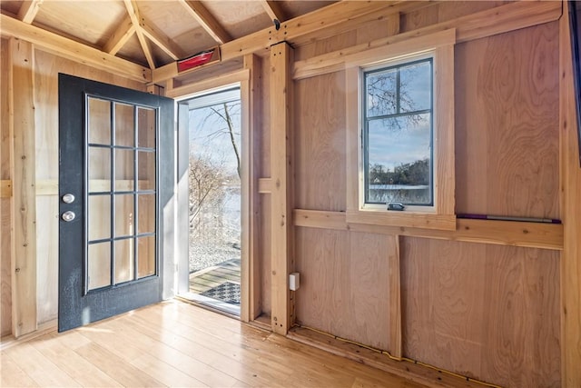 doorway to outside with wood finished floors and wood walls