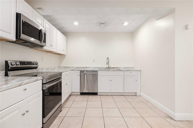 982 Plainfield St Unit 4, Johnston, RI 02919 - kitchen featuring appliances with stainless steel finishes, a sink, white cabinets, light tile patterned floors, and recessed lighting