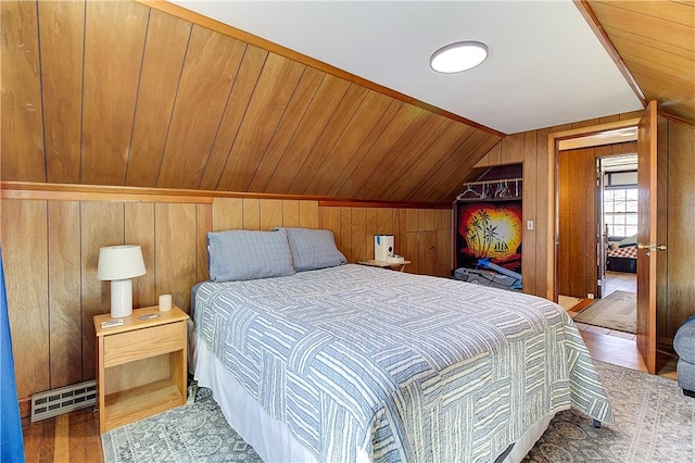 bedroom featuring wood finished floors, wooden walls, vaulted ceiling, and visible vents