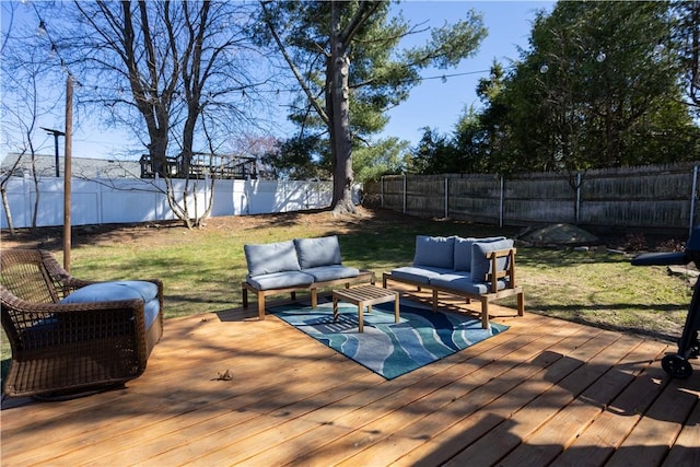 wooden terrace with a fenced backyard, outdoor lounge area, and a lawn