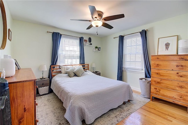 bedroom with light wood-style flooring, multiple windows, and ceiling fan