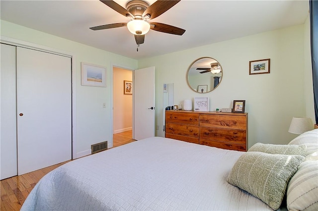 bedroom featuring a closet, visible vents, ceiling fan, and wood finished floors