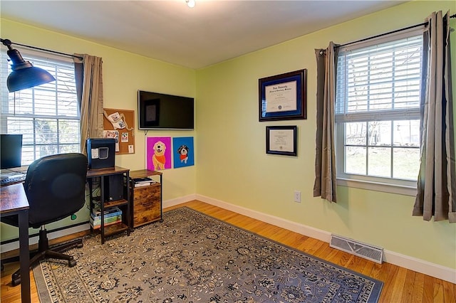 home office featuring wood finished floors, baseboards, and visible vents