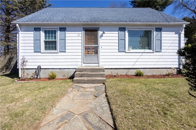 bungalow featuring a shingled roof and a front yard