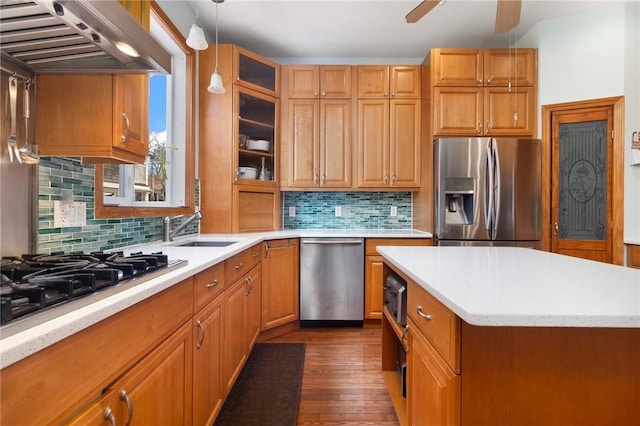 55 Hunter Ave, Newport, RI 02840 - kitchen featuring light countertops, a sink, wall chimney exhaust hood, appliances with stainless steel finishes, and dark wood-type flooring