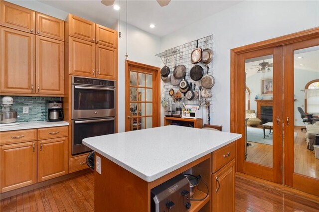55 Hunter Ave, Newport, RI 02840 - kitchen with light countertops, tasteful backsplash, dark wood-type flooring, double oven, and a ceiling fan