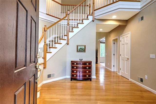 entryway featuring visible vents, wood finished floors, and stairway