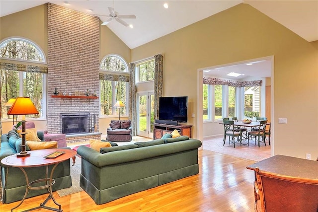 living area with a ceiling fan, high vaulted ceiling, and a wealth of natural light