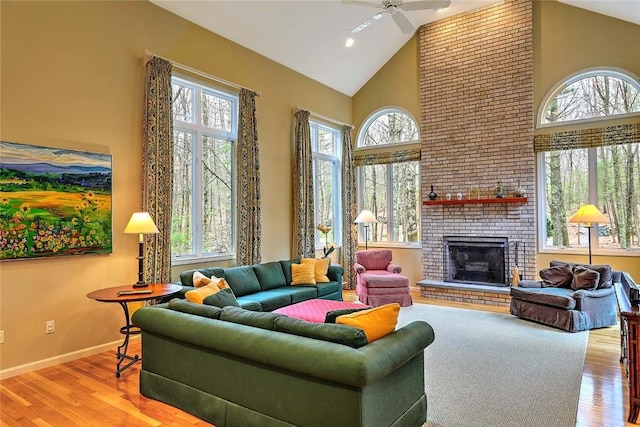 living room with a healthy amount of sunlight, high vaulted ceiling, a ceiling fan, and wood finished floors