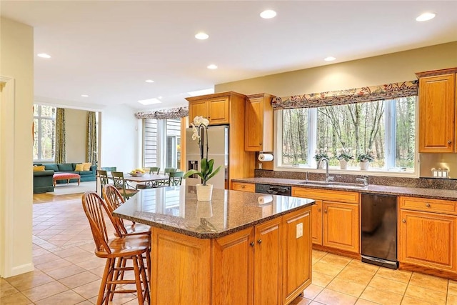 kitchen with a sink, black dishwasher, stainless steel refrigerator with ice dispenser, and a wealth of natural light