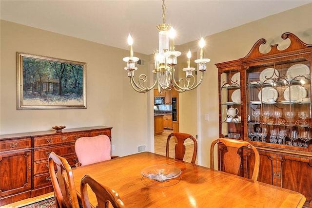 dining space featuring visible vents and a notable chandelier