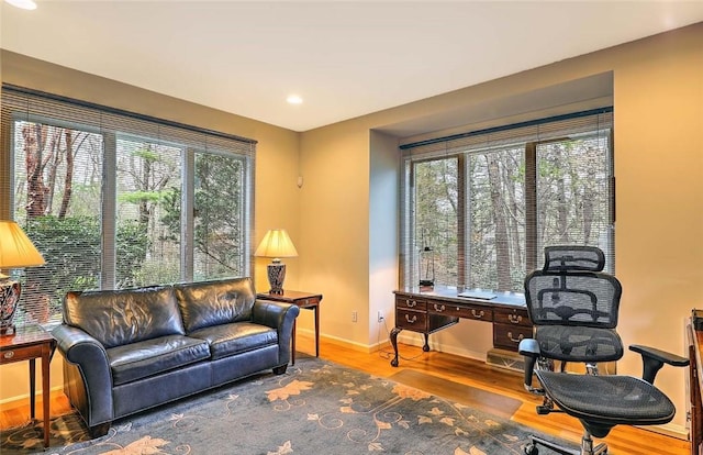 home office with recessed lighting, baseboards, a healthy amount of sunlight, and wood finished floors