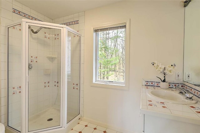 full bathroom with baseboards, a healthy amount of sunlight, and a shower stall