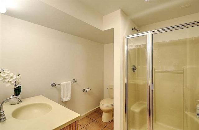 full bath with a sink, tile patterned floors, a shower stall, and toilet
