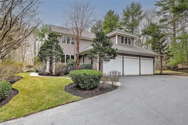 view of front of home with driveway, a front yard, and a garage
