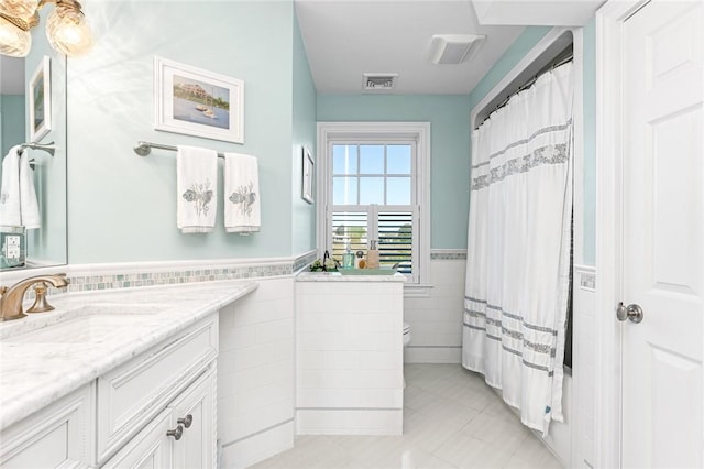 7 Fenway Rd, Westerly, RI 02891 - bathroom featuring toilet, tile walls, wainscoting, visible vents, and vanity