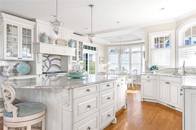 7 Fenway Rd, Westerly, RI 02891 - kitchen featuring crown molding, a chandelier, light wood-style flooring, backsplash, and white cabinetry