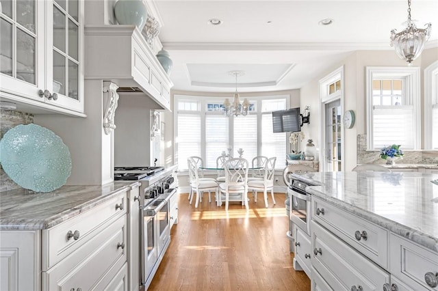 7 Fenway Rd, Westerly, RI 02891 - kitchen featuring white cabinets, light wood-type flooring, a chandelier, glass insert cabinets, and appliances with stainless steel finishes
